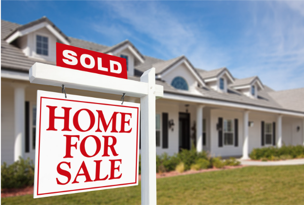 for sale sign posted in front of a house. The home is for sale